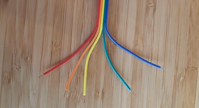 5 colourful wires of a ribbon cable with the end few centimetres split apart into a fan-like shape.